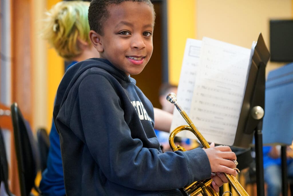 Child with a trumpet smiling.
