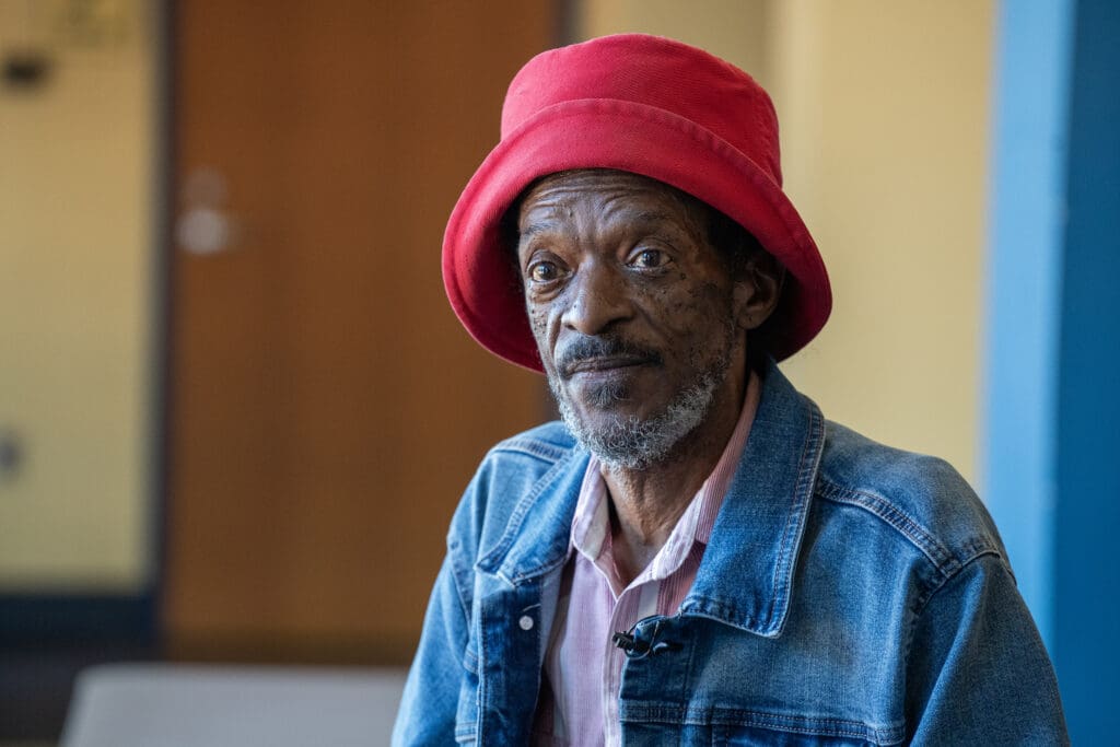 Musicians' Village resident in red hat and blue jean jacket.